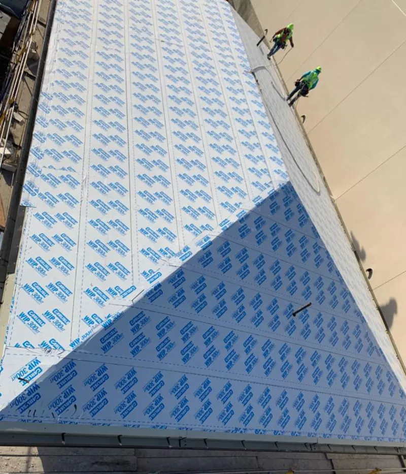 Professional roofers installing underlayment on a metal roof in Poquoson